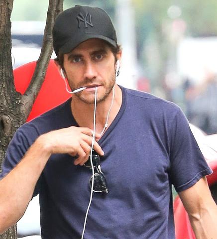 Foto do ator Jake Gyllenhaal com o fio de seus EarPods na boca